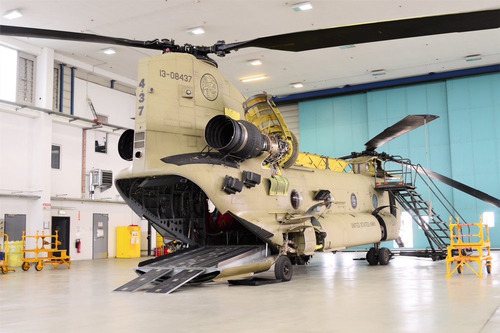A CH-47 Chinook helicopter with B Company, 1st General Support Aviation Battalion, 214th Aviation Regiment sits inside an aircraft maintenance hangar during repairs.