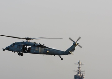 An MH-60S Sea Hawk hovers in front of USS John C. Stennis in the Red Sea