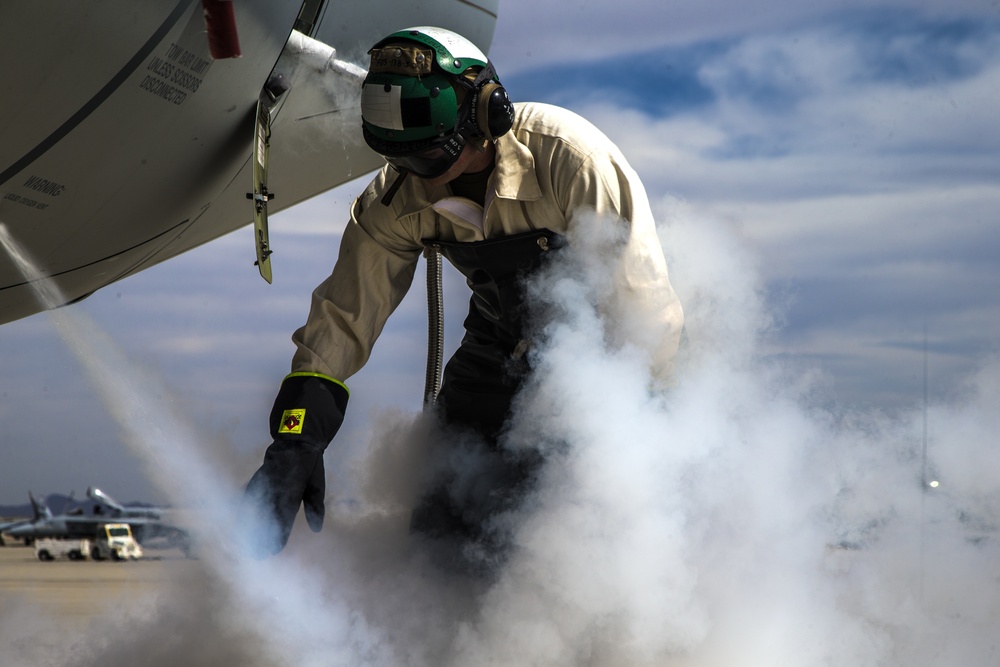 Marine services the oxygen system on a KC-130J Hercules during WTI 2-19