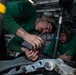 U.S. Sailors conduct maintenance on the scissors assembly of an MH-60S Sea Hawk