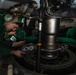 U.S. Sailors conduct maintenance on the scissors assembly of an MH-60S Sea Hawk