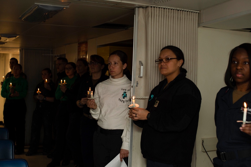 U.S. Sailors participate in a candlelight vigil during Sexual Assault Awareness and Prevention Month