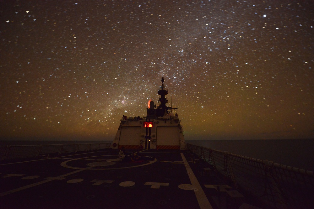 Bertholf sails under a night sky in the South China Sea