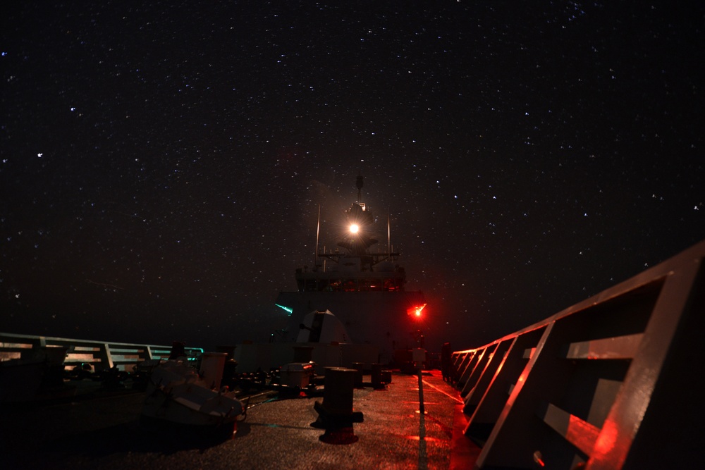Bertholf sails under a night sky in the South China Sea