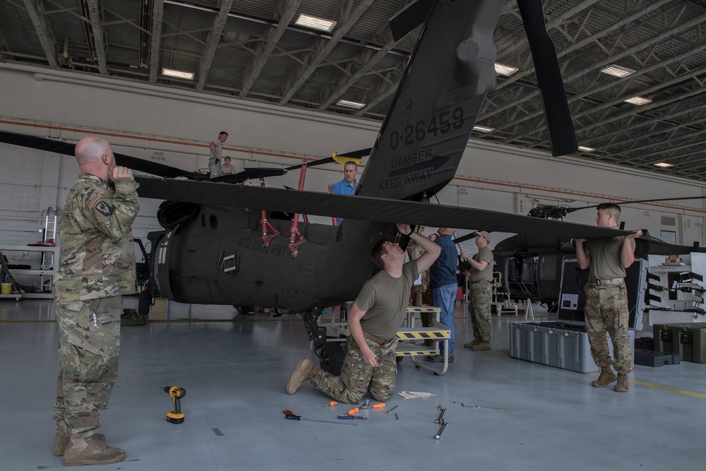 Soldiers removing the rear stabilizer from a UH-60 Black Hawk.