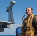 U.S. Sailor signals safety movements for an EA-18G Growler