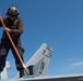 U.S. Sailors clean an F/A-18E Super Hornet
