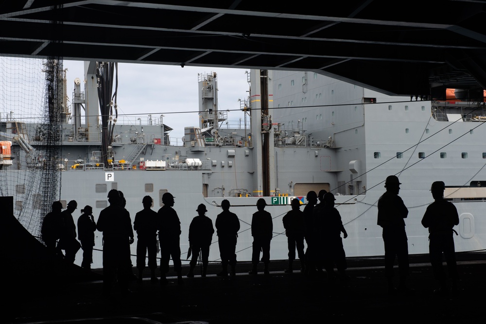 U.S. Sailors observe the dry cargo and ammunition ship USNS Charles Drew (T-AKE 10) conduct a replenishment-at-sea with the aircraft carrier USS John C. Stennis (CVN 74)