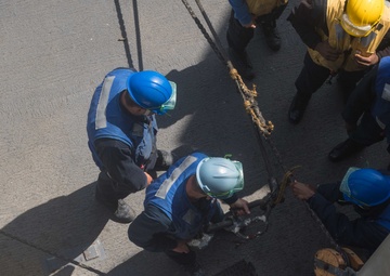 U.S. Sailors cut the manila line during a replenishment-at-sea
