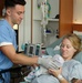 Hospital Corpsman Hands Newborn to Mother