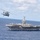 An MH-60S Sea Hawk, assigned to Helicopter Sea Combat Squadron (HSC) 14, flies alongside the aircraft carrier USS John C. Stennis (CVN 74 An MH-60S Sea Hawk, assigned to Helicopter Sea Combat Squadron (HSC) 14, flies alongside the aircraft carrier USS John C. Stennis (CVN 74
