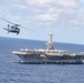 An MH-60S Sea Hawk, assigned to Helicopter Sea Combat Squadron (HSC) 14, flies alongside the aircraft carrier USS John C. Stennis (CVN 74