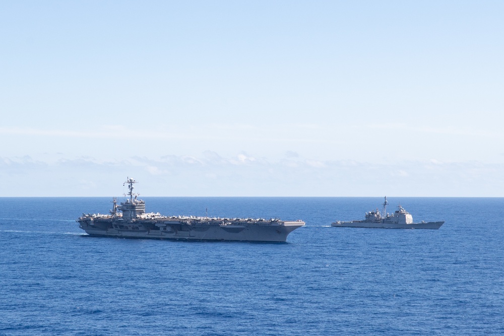 The aircraft carrier USS John C. Stennis (CVN 74), left, and the guided-missile cruiser USS Mobile Bay (CG 53) sail through the Atlantic Ocean