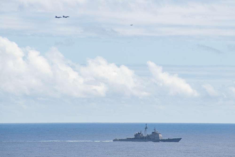 Aircraft fly over the guided-missile cruiser USS Mobile Bay (CG 53)