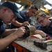 U.S. Sailors conduct a motor rewind