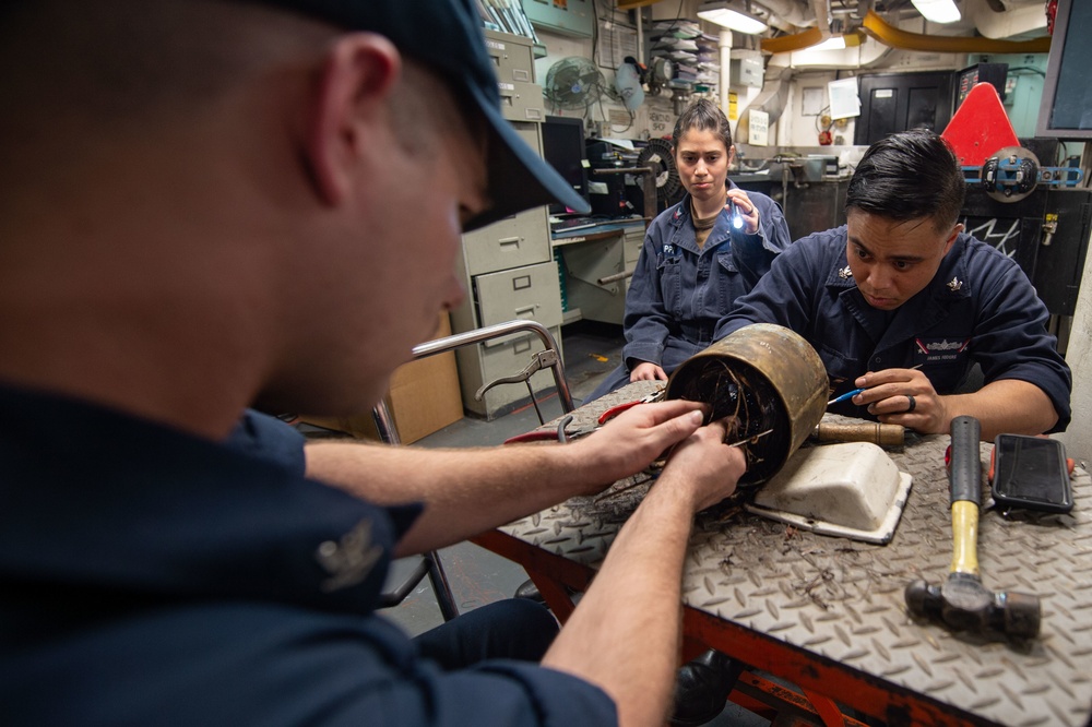 U.S. Sailors conduct a motor rewind