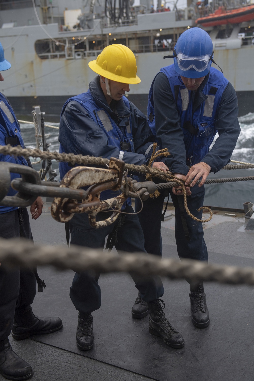 Boatswain’s Mate 3rd Class Dillon Dobbs, left, removes line from the cargo transfer cable during a replenishment-at-sea with the fleet replenishment oiler USNS Walter S. Diehl (T-AO 193)