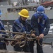 Boatswain’s Mate 3rd Class Dillon Dobbs, left, removes line from the cargo transfer cable during a replenishment-at-sea with the fleet replenishment oiler USNS Walter S. Diehl (T-AO 193)