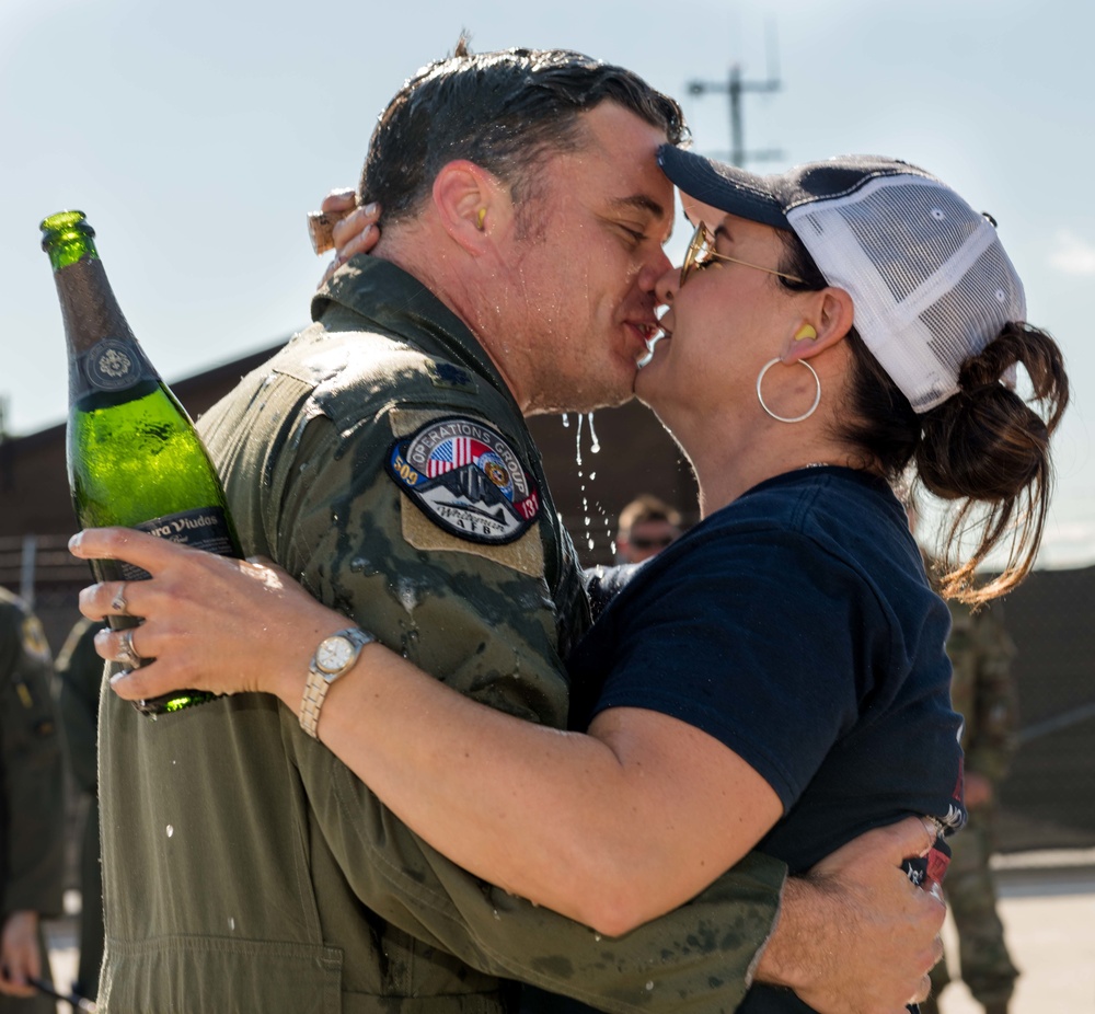 Lt. Col. Nickolas B. Adcock leans in to kiss his spouse after his final flight at Whiteman Air Force Base