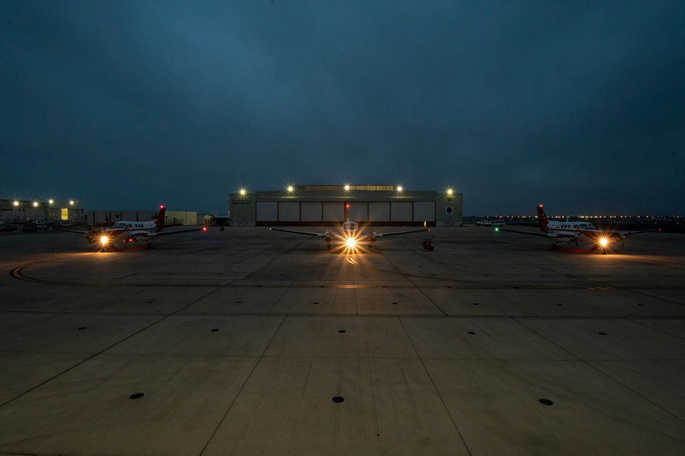 Three T-44C Pegasus aircraft sit aboard the Naval Air Station Corpus Christi flightline