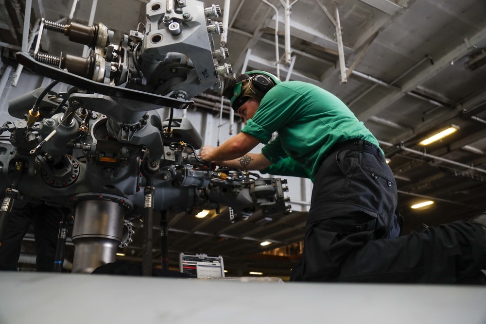 Maintenance in the hangar bay of the Nimitz-class aircraft carrier USS Abraham Lincoln (CVN 72).