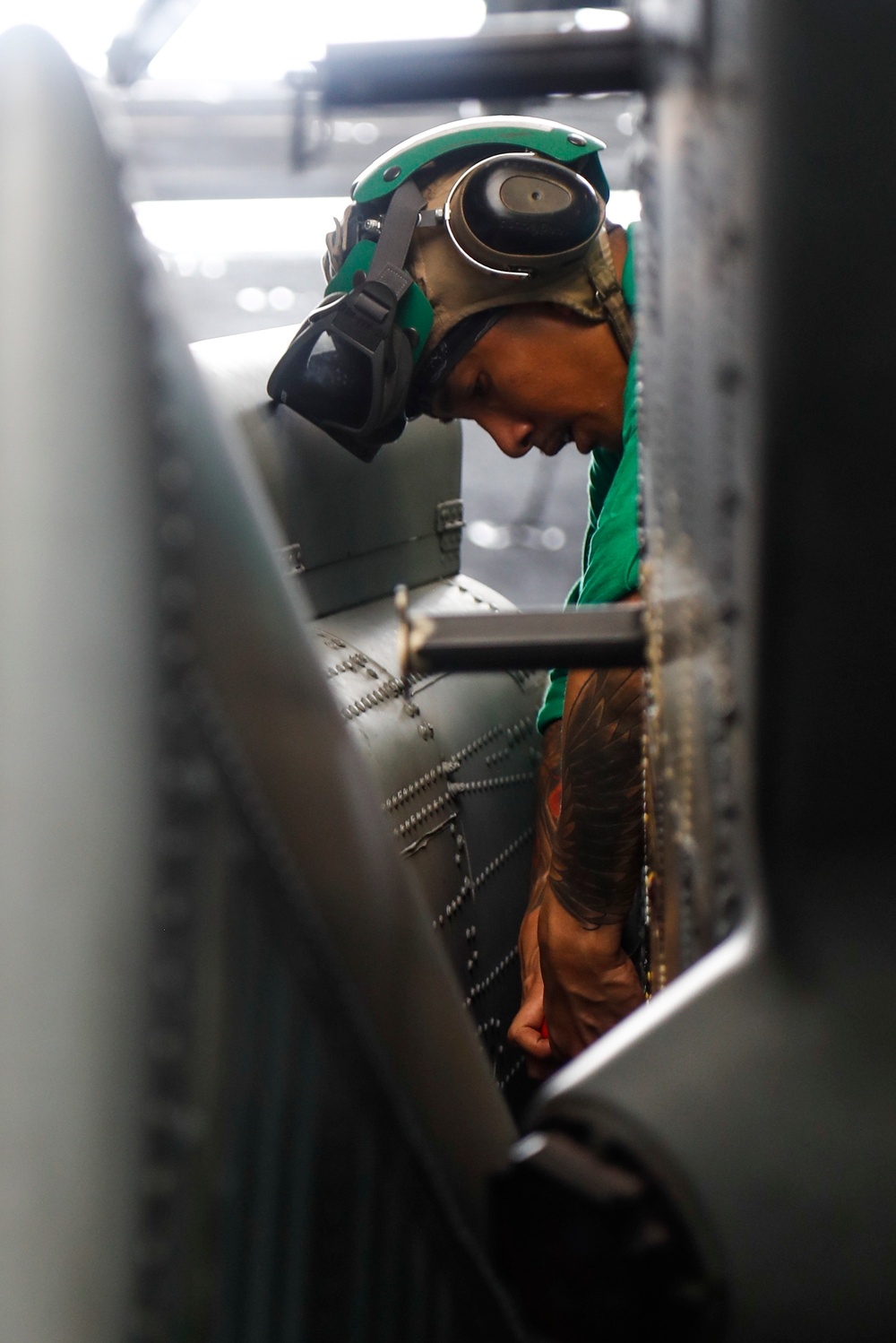 Maintenance in the hangar bay of the Nimitz-class aircraft carrier USS Abraham Lincoln (CVN 72).