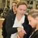 Nurses from AUM inspect a realistic prosthetic arm while at Walter Reed Bethesda