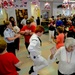 Gunner’s Mate 2nd Class Christian Rosas, attached to USS Milwaukee (LCS 5), dances with members of the Arrochar Friendship Club