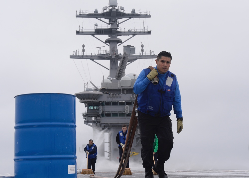 Nimitz Sailor Carries Hose