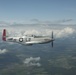 Scat VII, Robin Olds' P-51 Mustang, flies along Spangdahlem F-16C aircraft