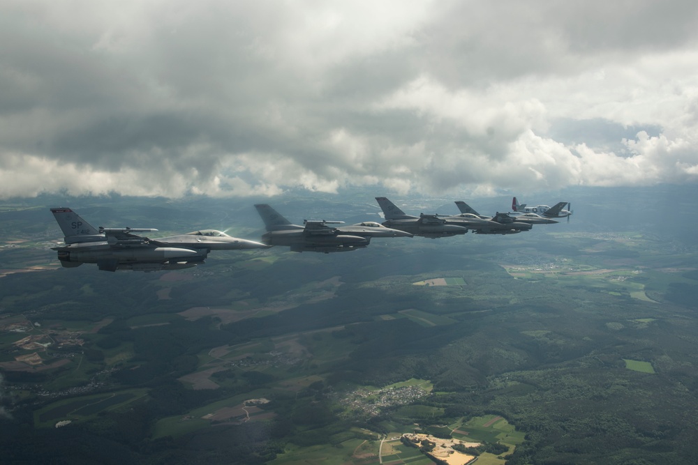 Scat VII, Robin Olds' P-51 Mustang, flies along Spangdahlem F-16C aircraft