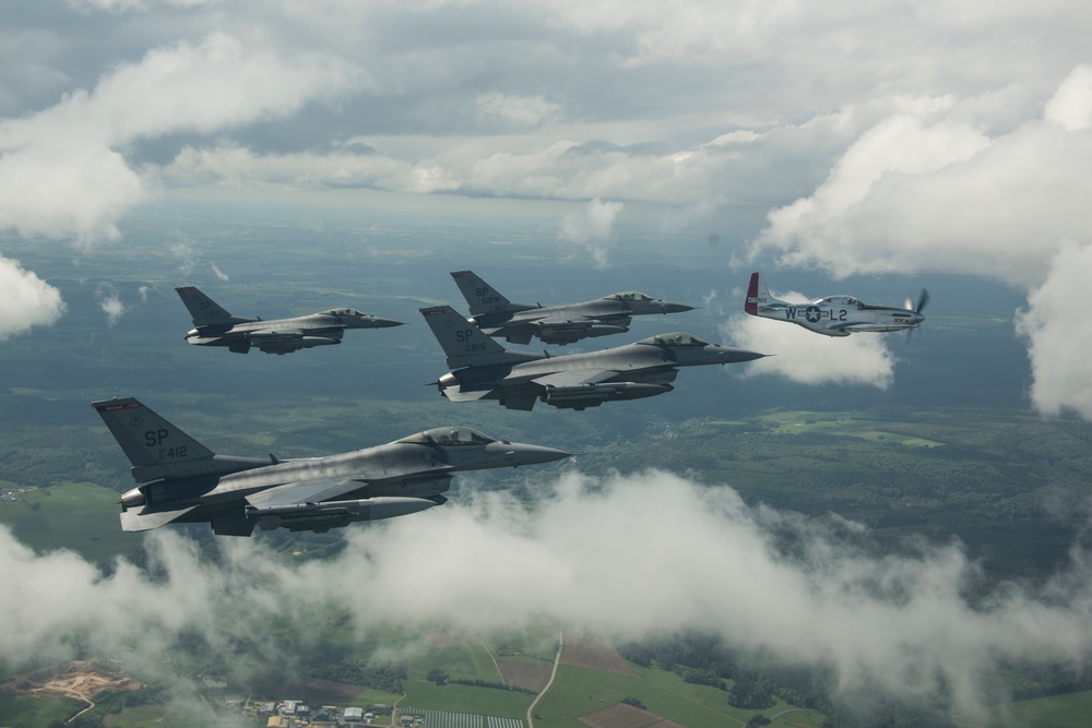 Scat VII, Robin Olds' P-51 Mustang, flies along Spangdahlem F-16C aircraft