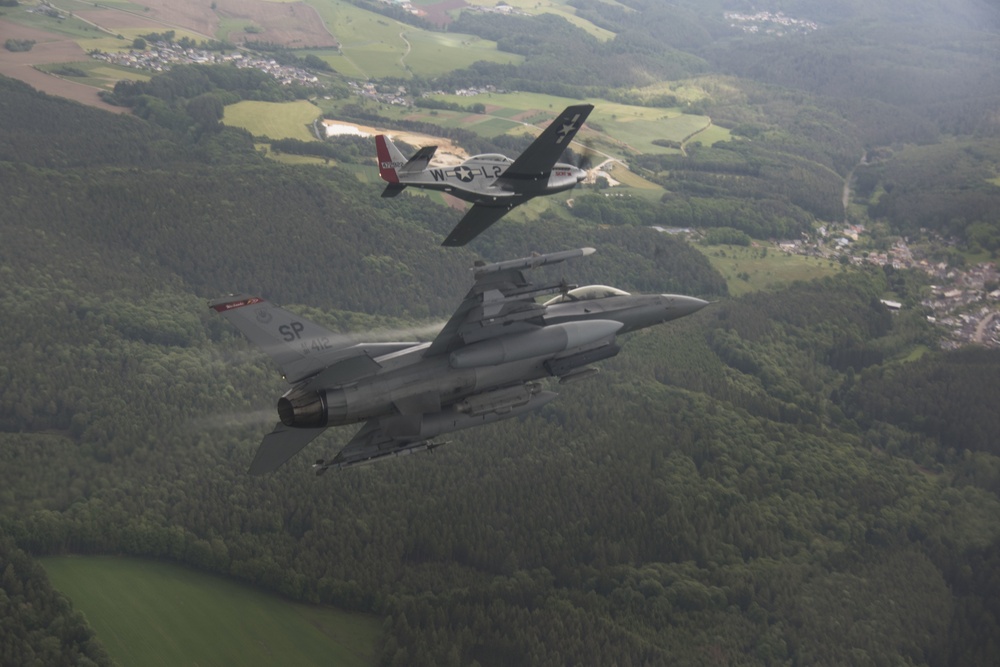 Scat VII, Robin Olds' P-51 Mustang, flies along Spangdahlem F-16C aircraft