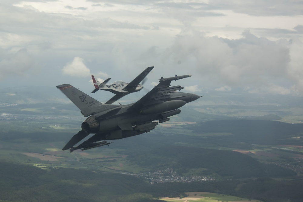 Scat VII, Robin Olds' P-51 Mustang, flies along Spangdahlem F-16C aircraft