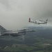 Scat VII, Robin Olds' P-51 Mustang, flies along Spangdahlem F-16C aircraft