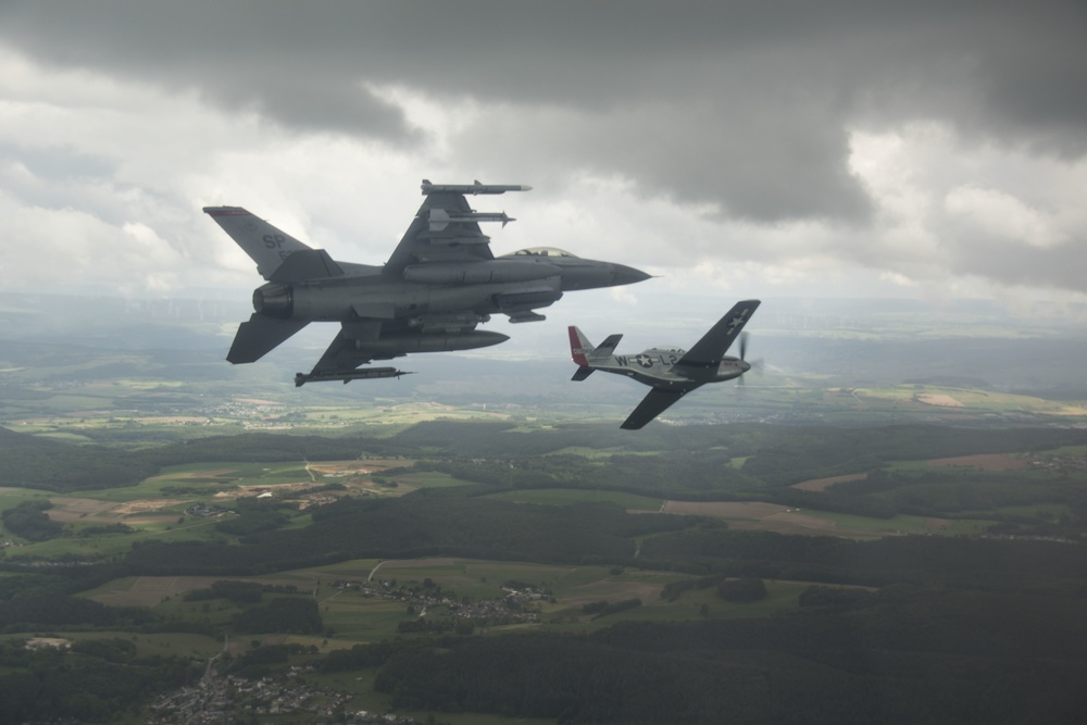 Scat VII, Robin Olds' P-51 Mustang, flies along Spangdahlem F-16C aircraft