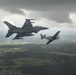 Scat VII, Robin Olds' P-51 Mustang, flies along Spangdahlem F-16C aircraft