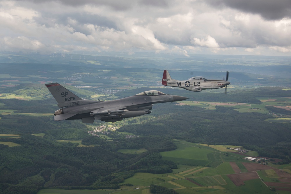 Scat VII, Robin Olds' P-51 Mustang, flies along Spangdahlem F-16C aircraft