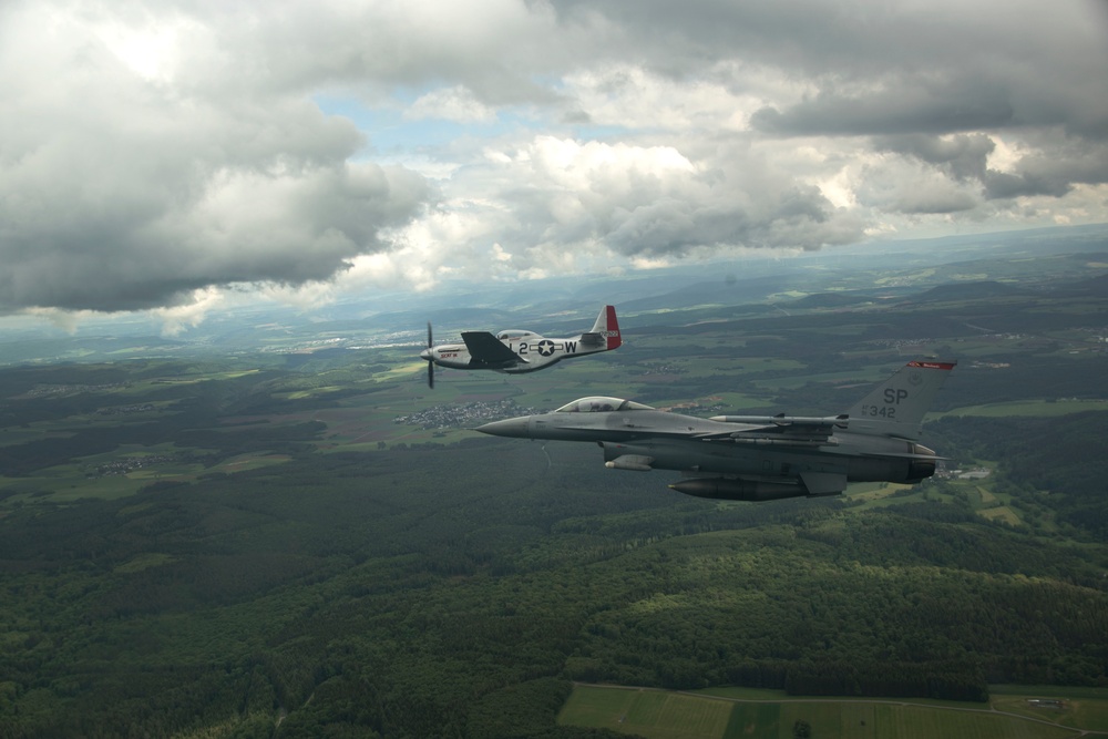 Scat VII, Robin Olds' P-51 Mustang, flies along Spangdahlem F-16C aircraft