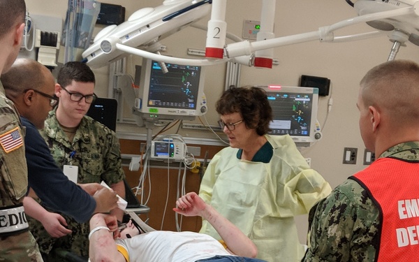 A 'patient' is prepared to move onto an emergency room exam table.
