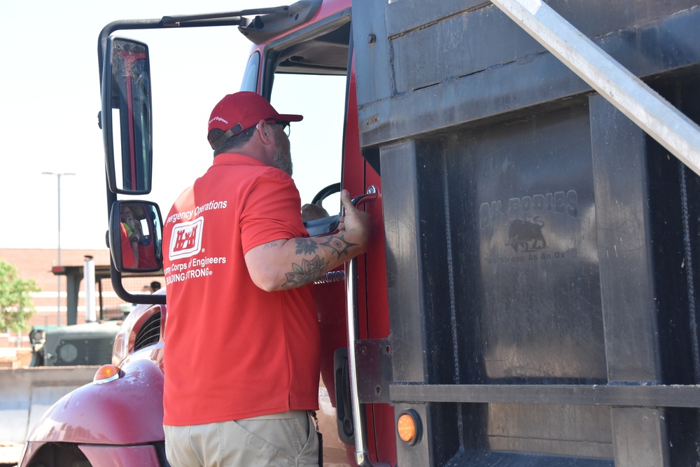 Teamwork fills sandbags along the Arkansas River
