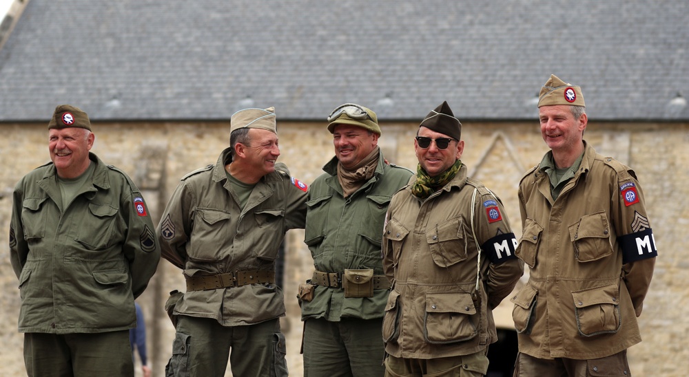 Service Member re-enactors in front of the Church of St. Mary, Ste Mere Eglise
