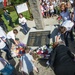 Children offer flowers and flags