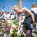 Children lay flowers at base of memorial