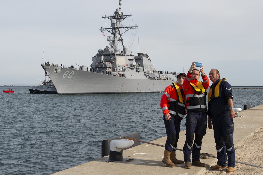 Three French, line handlers take photo with destroyer.
