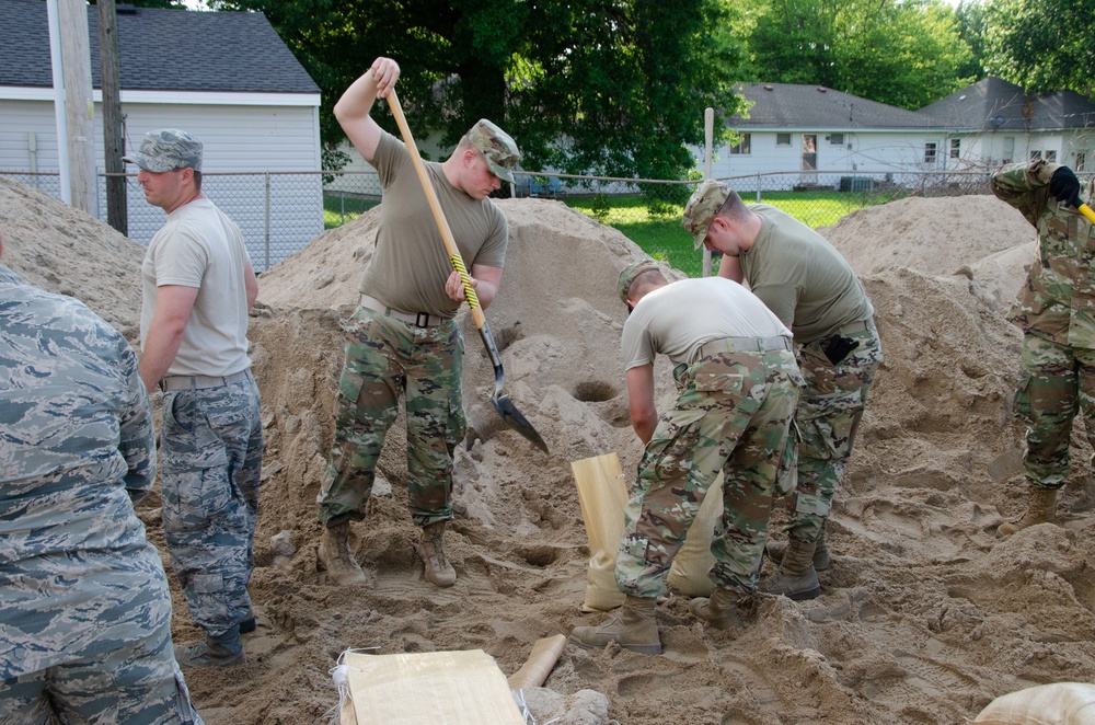 Airmen fill sand bags for flood fighting