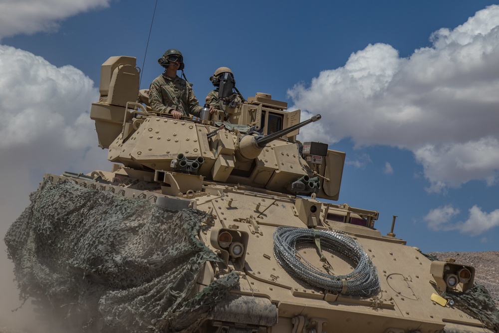 Soldiers from 1st Battalion, 163rd Cavalry Regiment, Montana Army National Guard, push on in their Bradley Fighting Vehicle during a defensive attack training exercise at the National Training Center (NTC) in Fort Irwin, Calif.