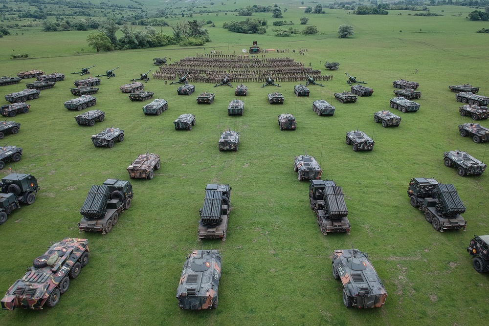 A static display of Romanian Land Force vehicles are staged in the background of the opening ceremony of Saber Guardian 2019