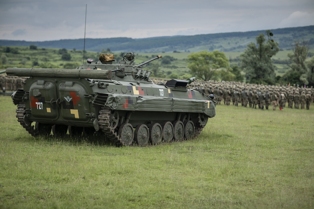 An armored vehicle static display from the Romanian Land Forces is staged in the background of the opening ceremony of Saber Guardian 2019