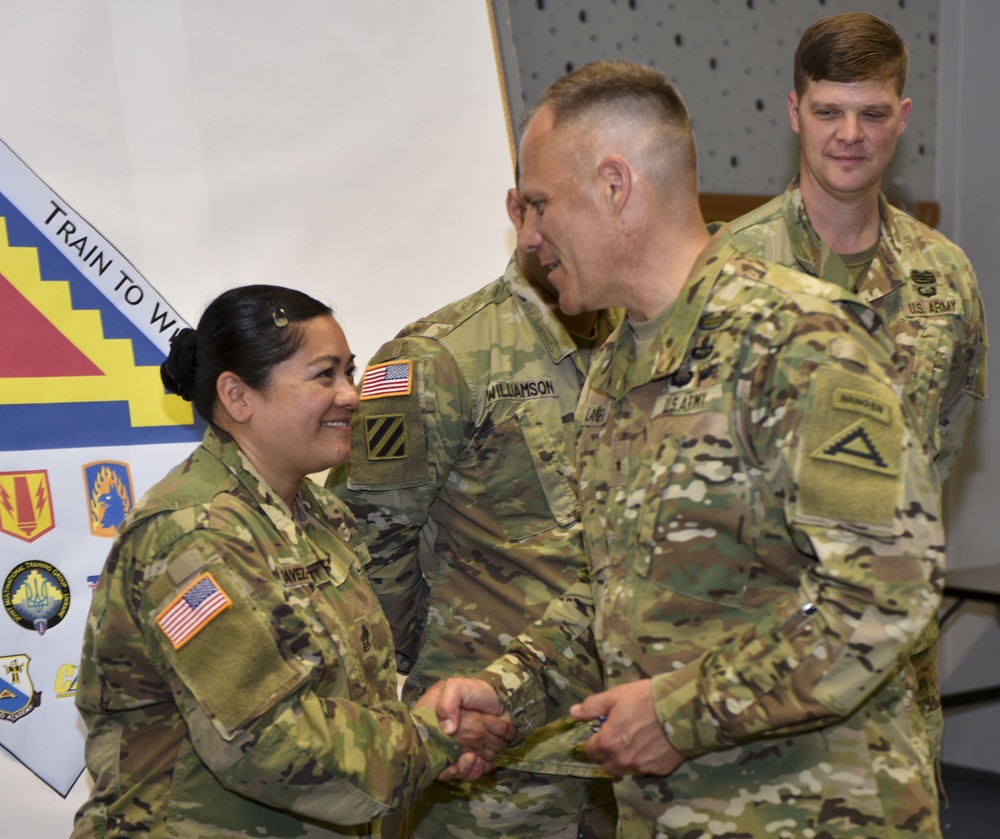 Master Sgt. Annalita Chavez-Pratt receives coin at the summer exercises command.